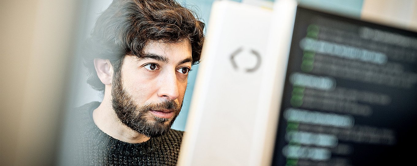 Porträtfoto von Gerardo Lopez, Interface Designer bei Körber Digital, bei der Arbeit am Computer