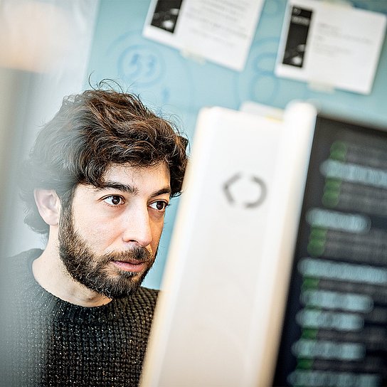 Porträtfoto von Gerardo Lopez, Interface Designer bei Körber Digital, bei der Arbeit am Computer